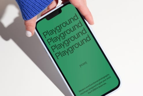 Hand holding smartphone displaying green screen with repeated text Playground perfect for modern mockup design projects digital assets for designers.