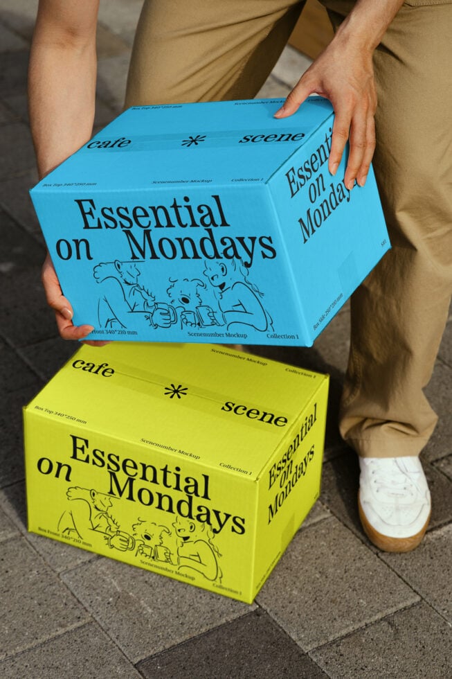 Two colorful Essential on Mondays boxes held by a person on pavement. Modern packaging graphics mockup for designers. Creative design asset template.