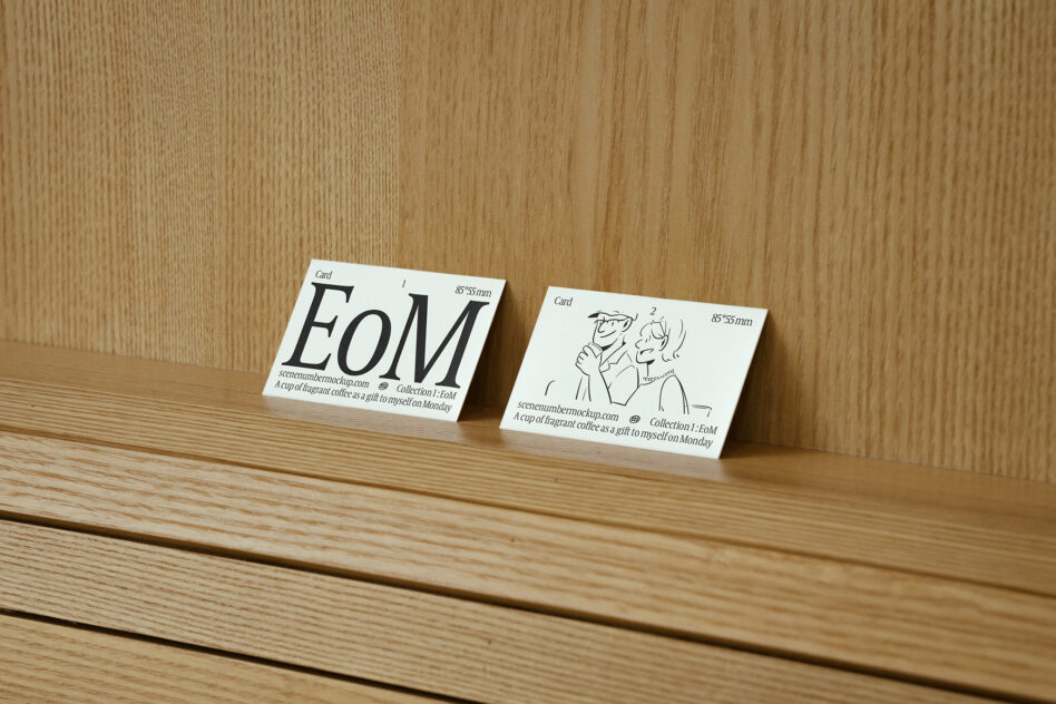 White business cards fanned on wood surface with EOM logo