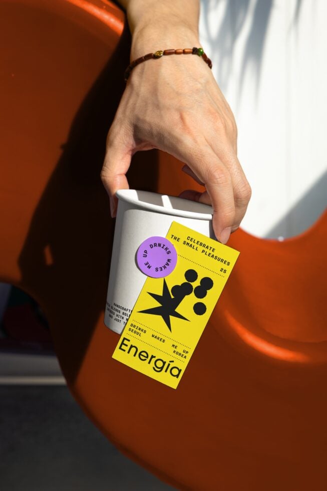 Hand holding a coffee cup with vibrant branding label. Ideal for mockup use. Keywords: cup mockup, branding, packaging design, vibrant colors, product.