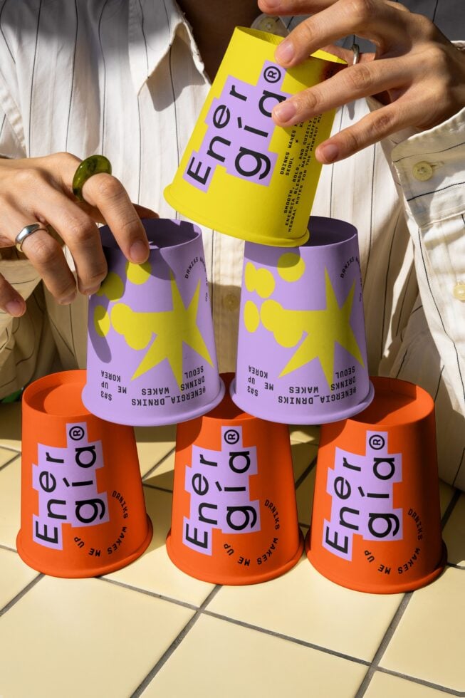 Colorful stack of paper cups with bold text and star graphics. Ideal for mockups and branding design. Vibrant and modern for creative projects.