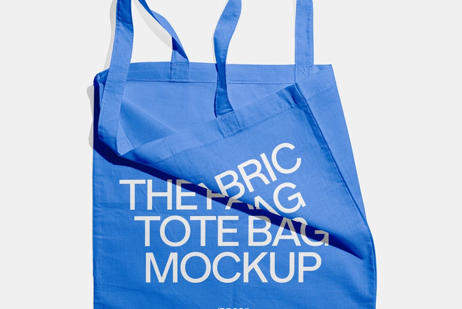 Bright blue tote bag with white text overlay showing crumpled fabric detail