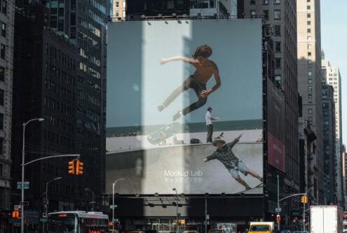 Billboard mockup on a city street showcasing skateboarders, ideal for showcasing urban scenes, sports graphics, and design concepts for mockup projects.