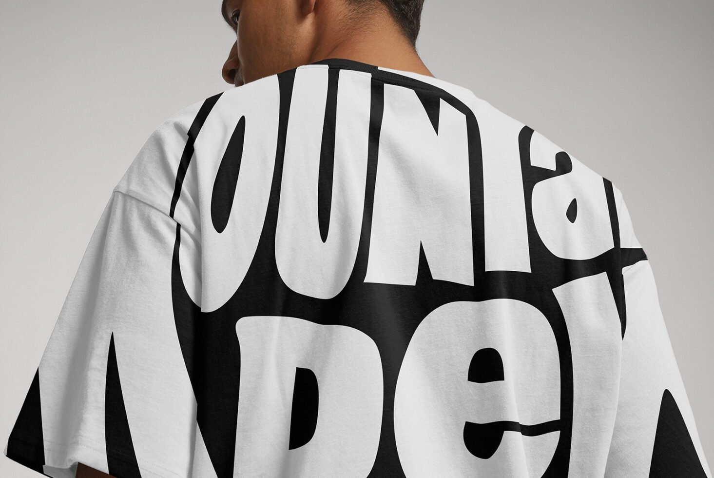 Back view of a T-shirt displaying bold black typography on white fabric. Suitable for graphic design lovers. Perfect for mockups and fashion templates.