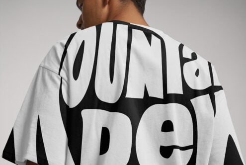 Back view of a T-shirt displaying bold black typography on white fabric. Suitable for graphic design lovers. Perfect for mockups and fashion templates.