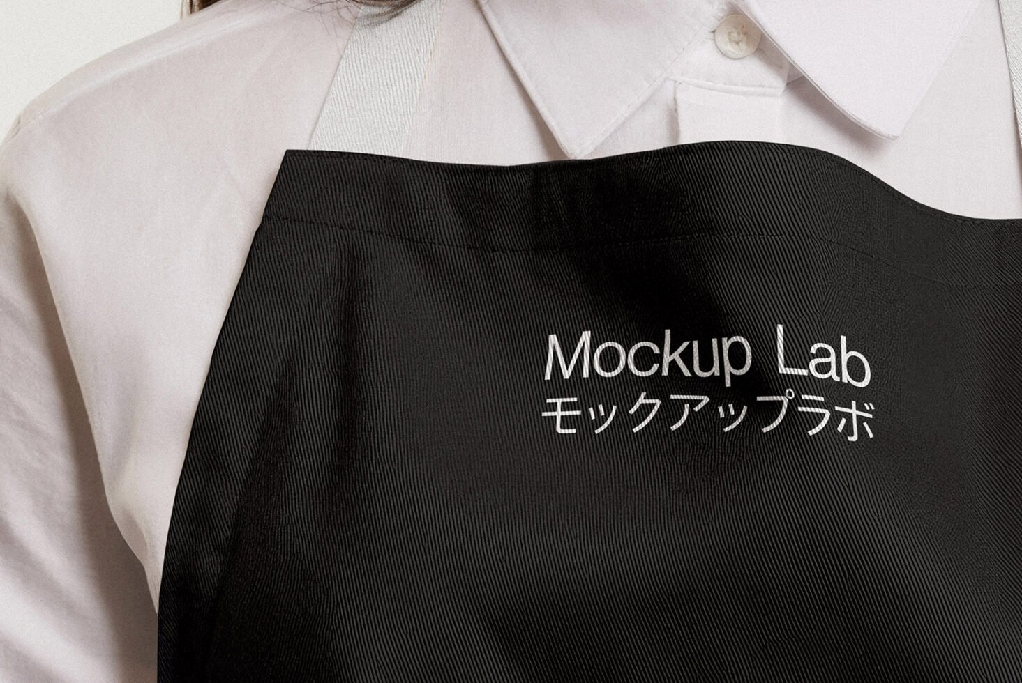 Close-up of a black apron mockup design featuring embroidered text Mockup Lab suitable for designers in templates and graphics asset marketplace.