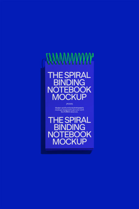 Spiral notebook with bright green metal coils on solid blue backdrop