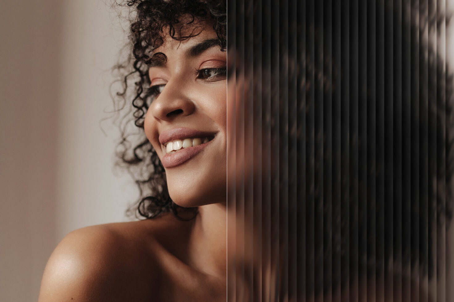 Portrait of a woman with curly hair and smooth skin. Half of the image is distorted with vertical lines. Perfect for photo editing mockup or design projects.