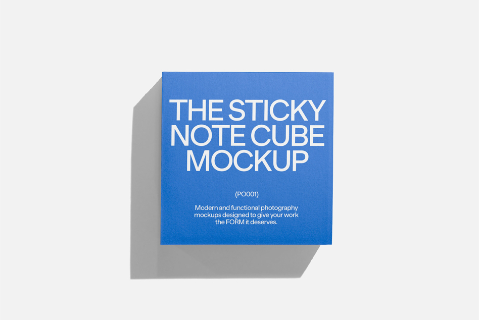 Bright blue sticky note cube casting shadow on light gray