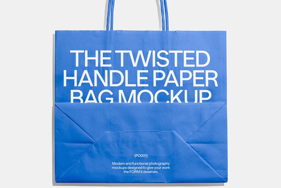 Blue paper shopping bag with twisted handles on light background with shadow