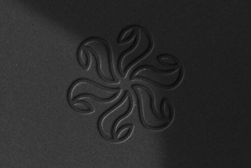 Dark embossed ornamental pattern with flowing curved petals radiating from center