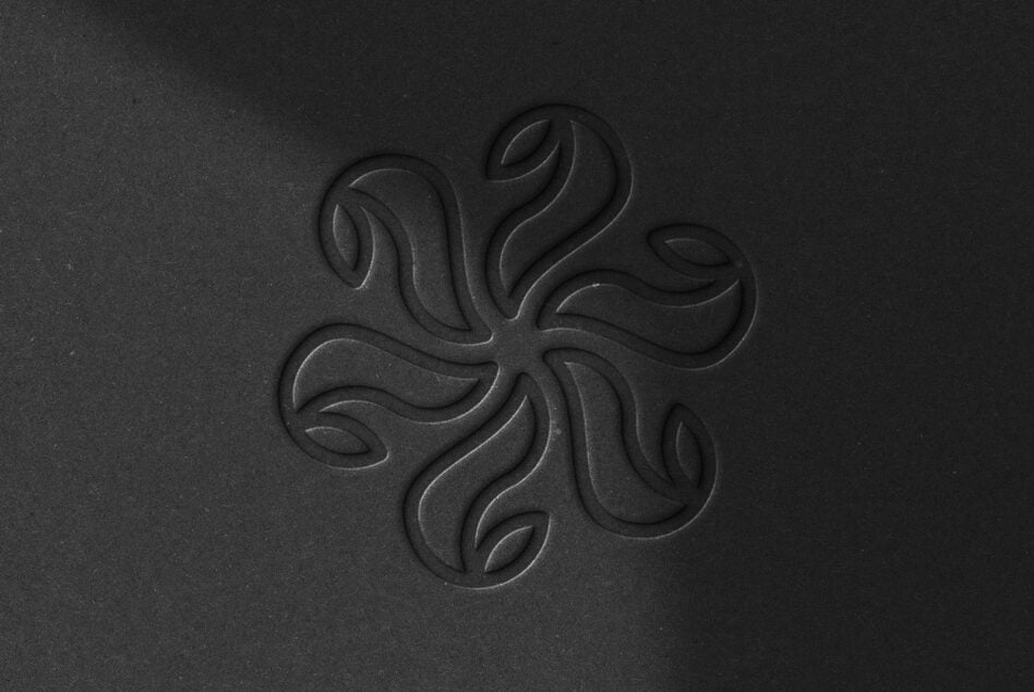 Dark embossed ornamental pattern with flowing curved petals radiating from center