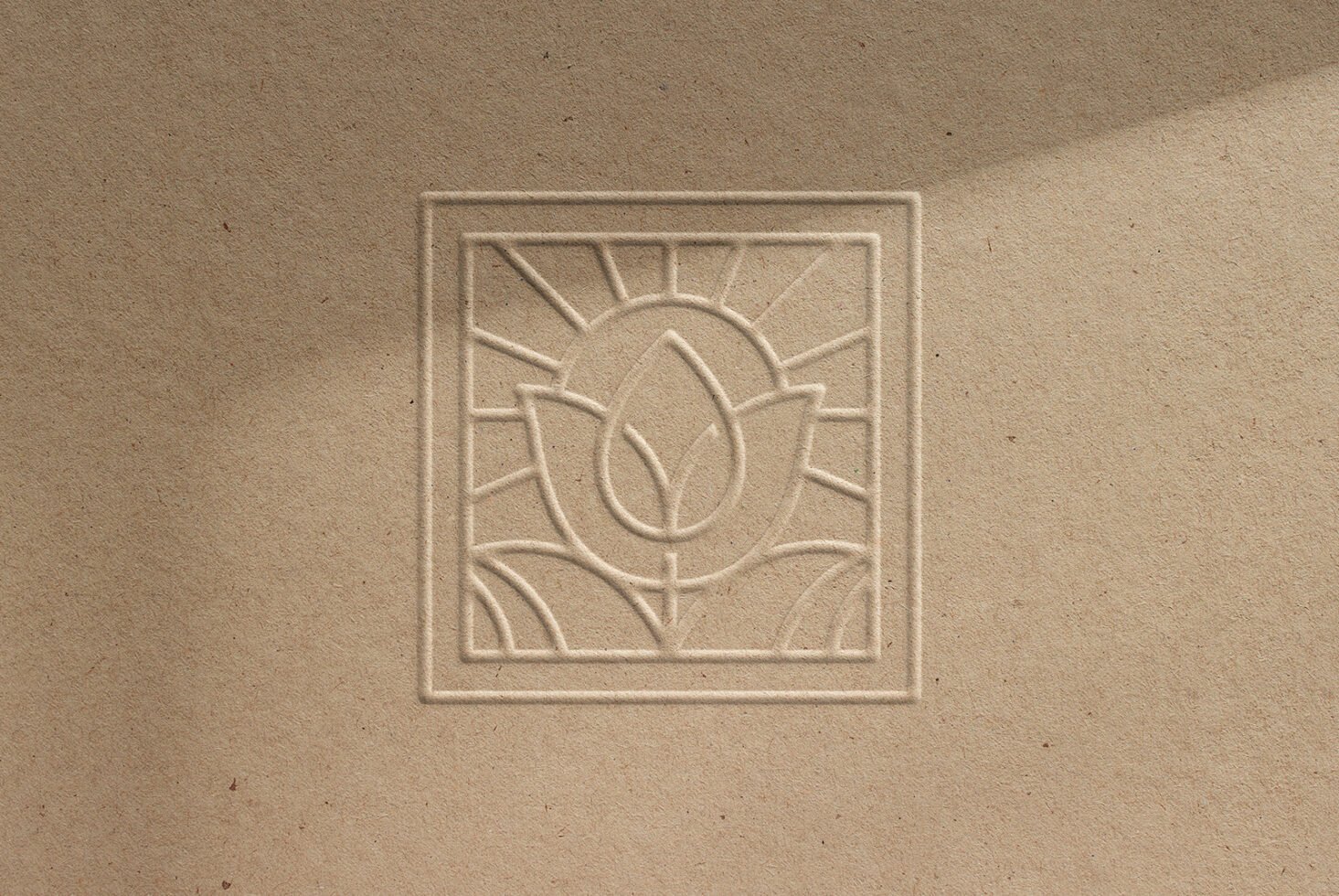 Embossed logo mockup featuring a minimalistic abstract floral design on textured paper ideal for graphic designers branding projects and presentations.