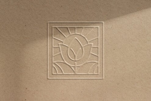 Embossed logo mockup featuring a minimalistic abstract floral design on textured paper ideal for graphic designers branding projects and presentations.