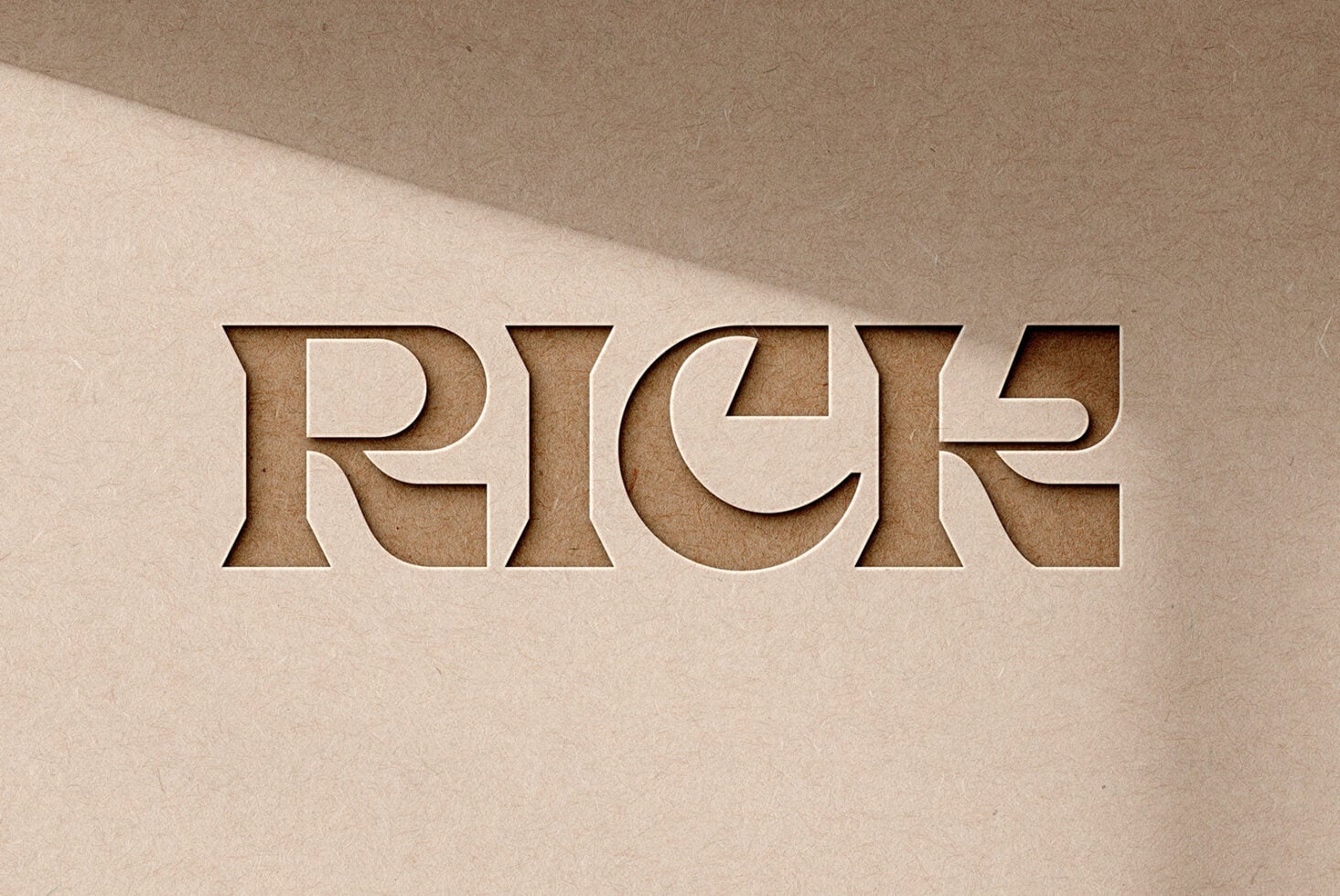 Embossed letters spelling RICE carved into tan cardstock with shadows