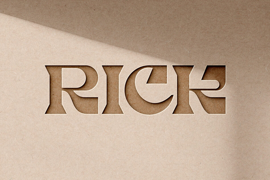 Embossed letters spelling RICE carved into tan cardstock with shadows