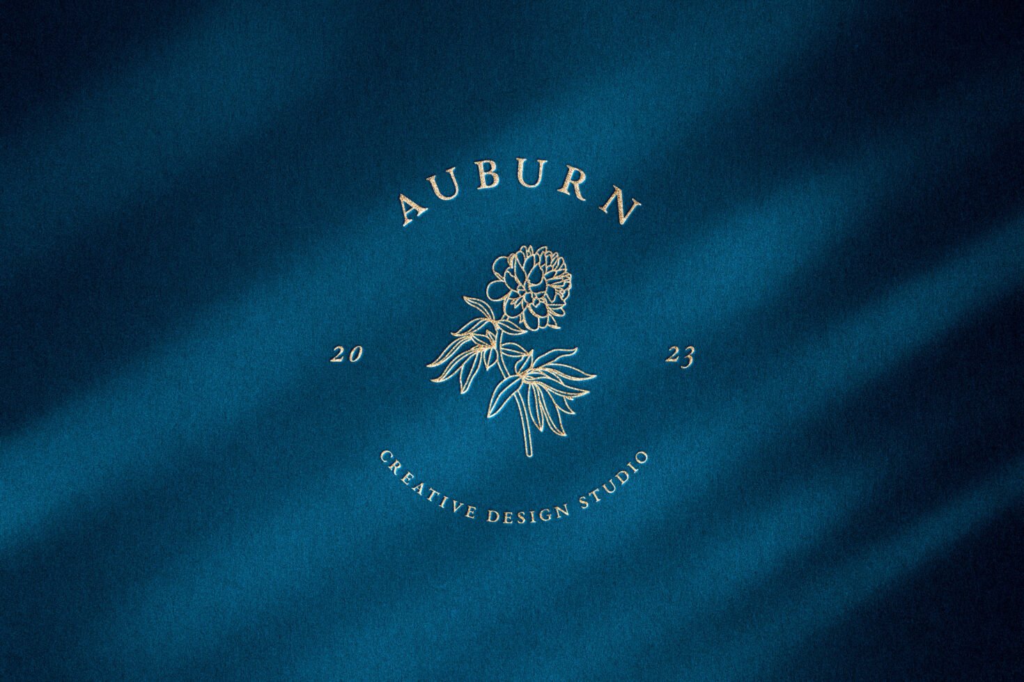Elegant logo design template features floral illustration with text Auburn Creative Design Studio on a textured blue background perfect for branding projects.