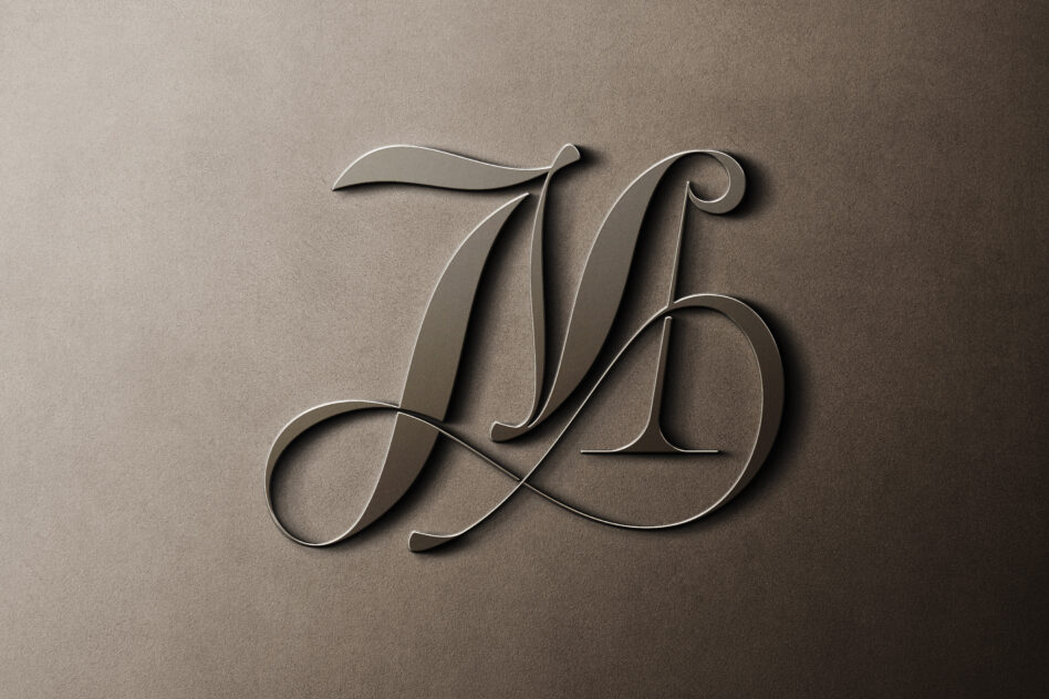 Engraved flowing script monogram with decorative flourishes on stone texture