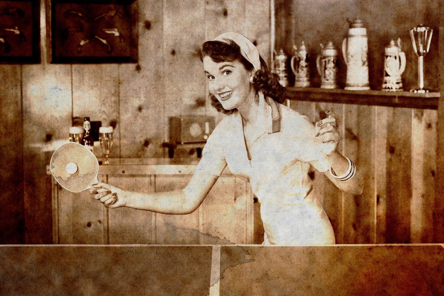 Vintage sepia photo of a smiling woman playing ping pong indoors, wearing retro clothing; ideal for graphic designers seeking nostalgic visual assets.