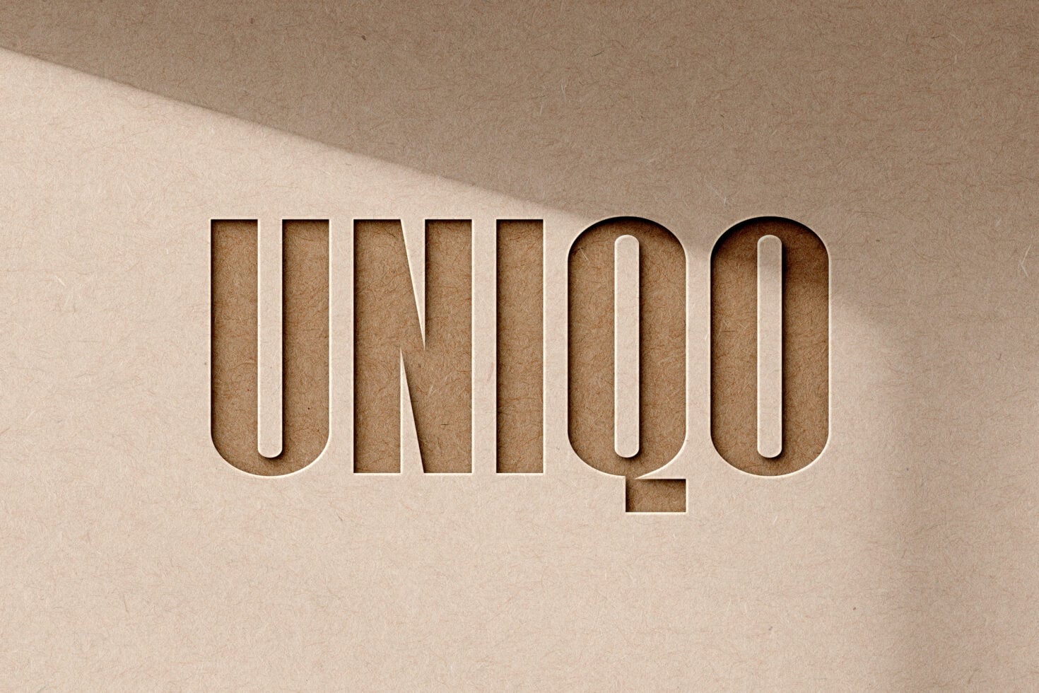 Layered cardboard cutout letters spelling UNIQOO with depth shadows