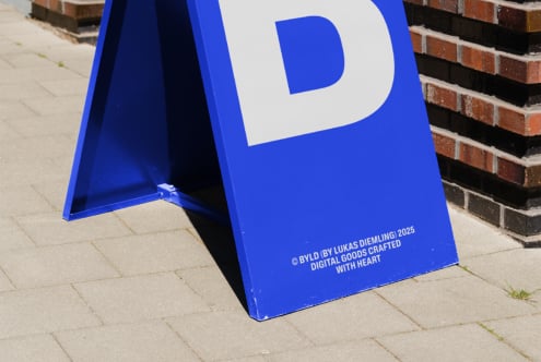Vibrant blue sandwich board with large white P letter on street