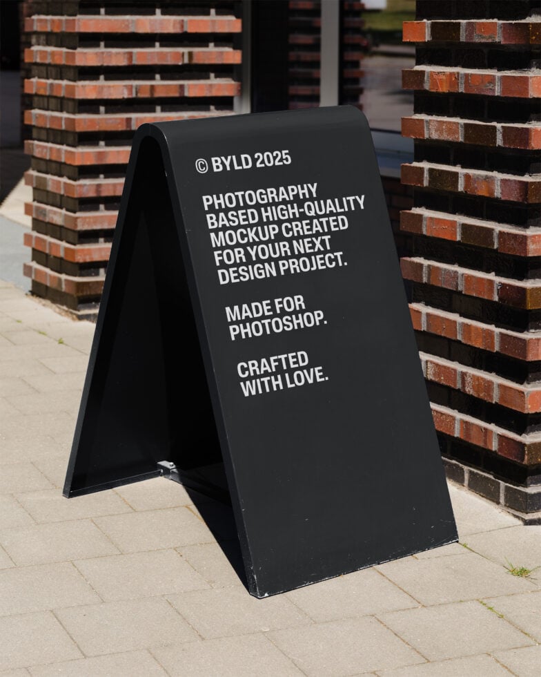 A-frame sign mockup outside brick building for Photoshop. High-quality design resource for graphic designers. Perfect for displaying branding projects.