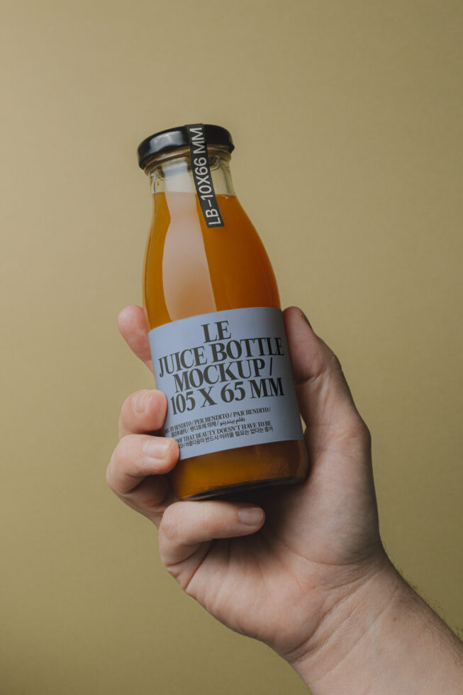 Juice bottle mockup held in hand against plain background. Ideal for branding, packaging design, and product presentation templates. Graphic design asset.