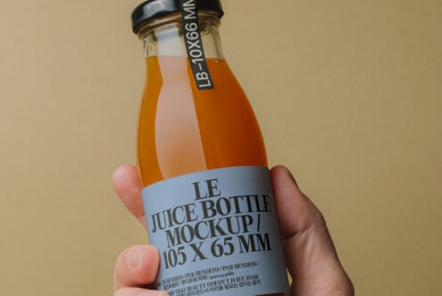 Juice bottle mockup held by a hand with detailed label. Perfect for designers seeking packaging templates, product presentation, and branding projects.