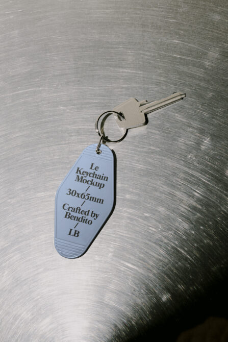 Vintage motel keychain in light blue on brushed metal textured surface