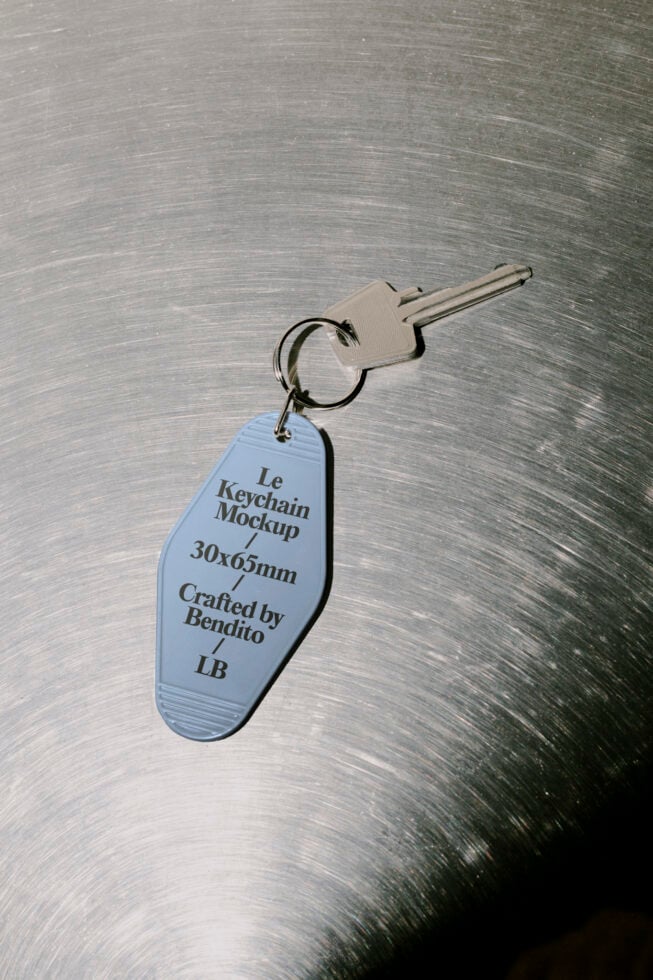 Keychain mockup on metallic surface featuring custom design with specifications. Ideal for showcasing branding or product design in graphic projects.