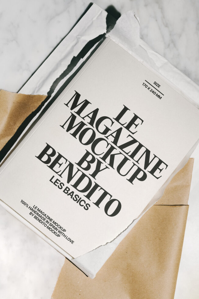 Magazine mockup template on marble background with kraft paper packaging ideal for designers seeking realistic print design mockups or editorial layouts