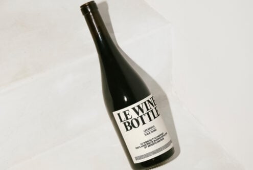 Standing wine bottle mockup with minimalist label on neutral background. Ideal for product design presentations. Keywords: wine, bottle, mockup, design.