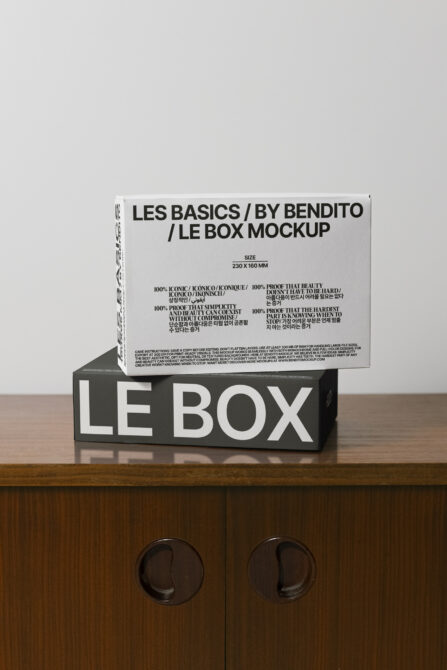 Stacked boxes showing white lid on black base with minimal typography design
