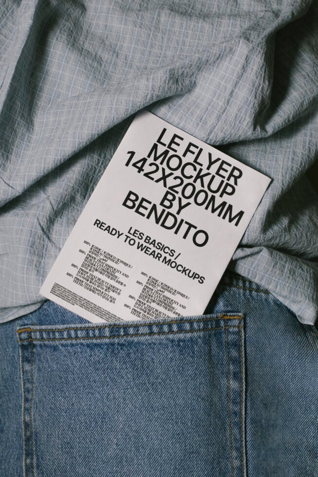 Le flyer mockup 142x200mm placed on denim and fabric, ideal for showcasing design projects. Perfect for designers seeking realistic mockup templates.
