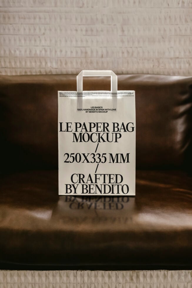 Mockup of a paper bag with bold text design placed on a leather seat, 250x335 mm, ideal for showcasing branding and packaging design.