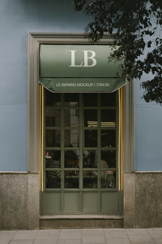 Green awning mockup over glass door in urban setting. Use for design projects and storefront presentations. Keywords: awning mockup design template.