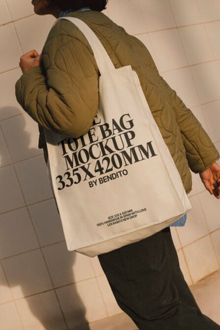 Person in puffer coat carrying cream canvas tote bag on back