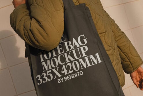 Person carrying a dark tote bag with text Tote Bag Mockup 335x420mm by Bendito, ideal for showcasing designs, templates, mockups for designers.