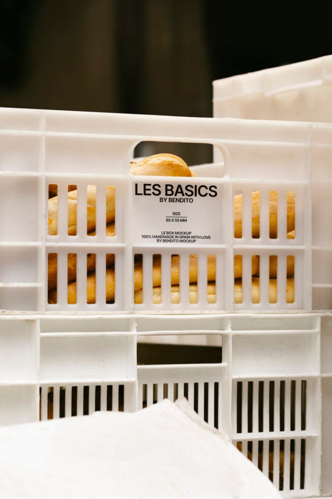 Mockup image featuring bread in a white plastic crate with label Les Basics by Bendito ideal for bakery branding packaging design SEO graphic designers.