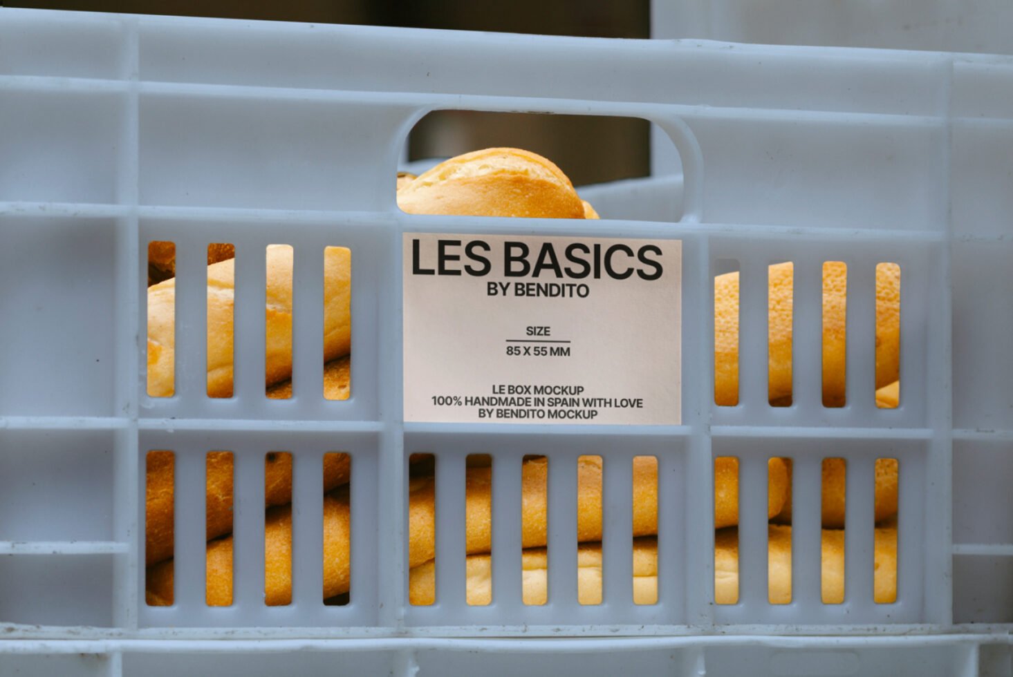 Blue crate with bread loaves inside labeled Les Basics by Bendito. Bakery food packaging mockup ideal for designers and branding projects.