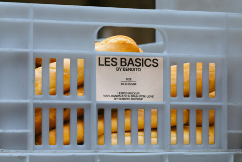 Blue crate with bread loaves inside labeled Les Basics by Bendito. Bakery food packaging mockup ideal for designers and branding projects.