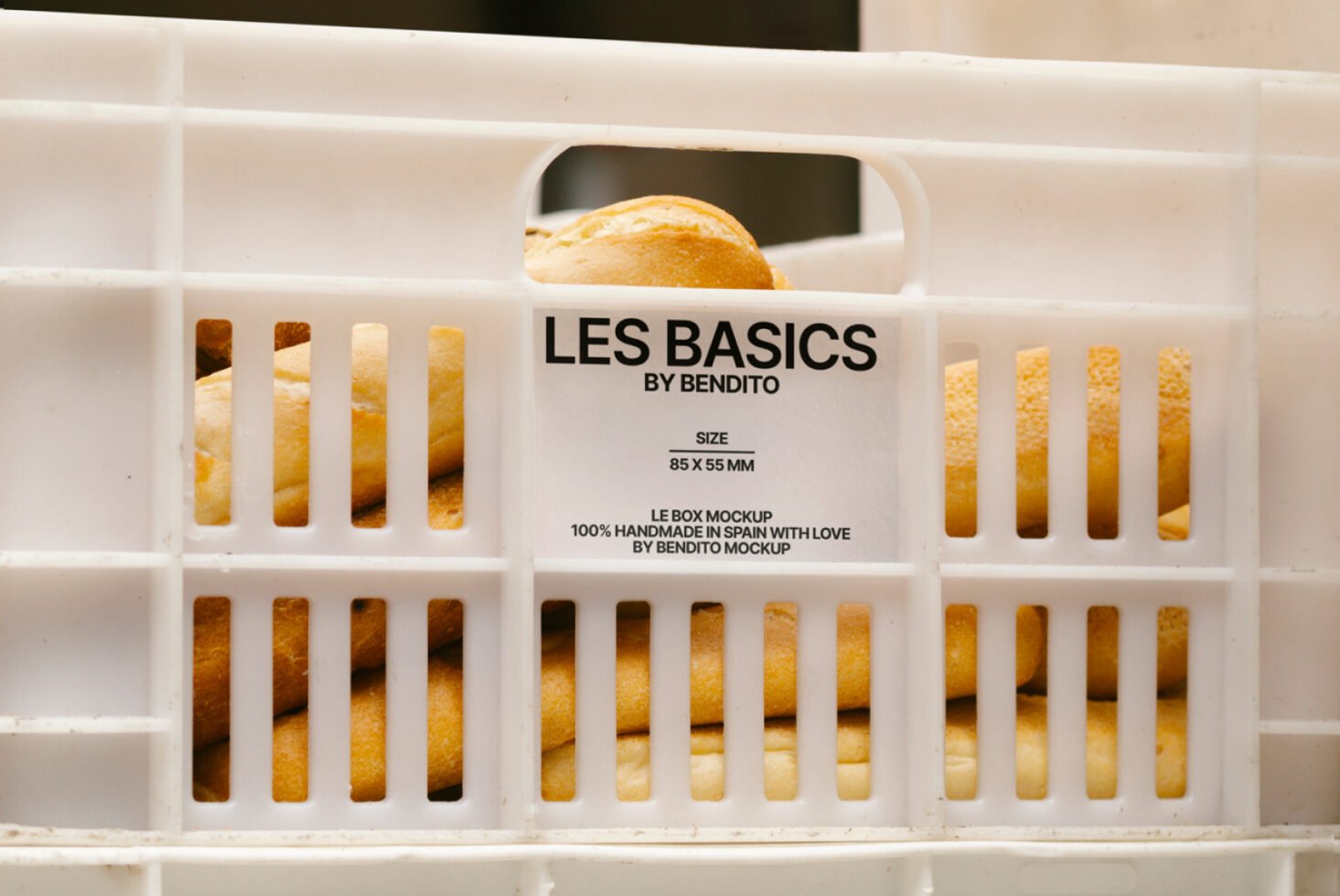 White crate filled with baguettes featuring Les Basics by Bendito label. Ideal for designers seeking realistic bread packaging mockups for creative projects.