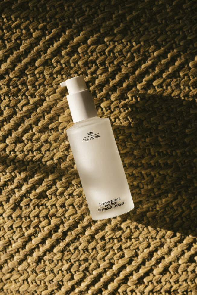 Frosted bottle mockup on textured surface ideal for designers. Soap dispenser template for branding projects and packaging design showcase.