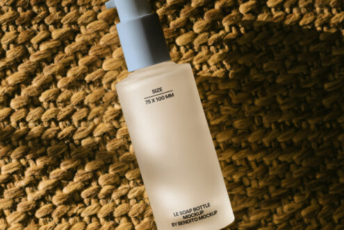 Soap bottle mockup on woven background for designers. Template with dimensions 75x100mm. Ideal for showcasing label designs in graphics projects.