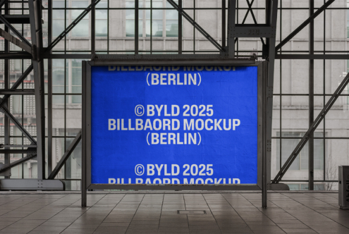 Electric blue lit billboard showing text in glass shelter with city views
