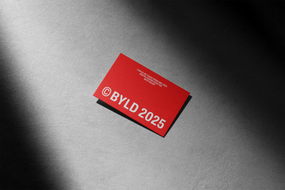 Red business card with white BYLD 2025 text on gray concrete surface