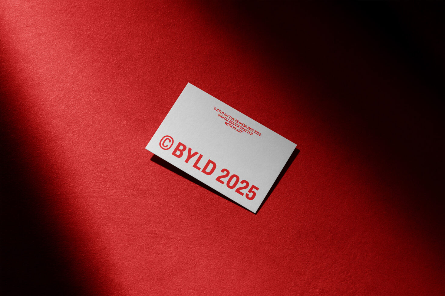 Business card mockup on a bold red textured background featuring modern typography suitable for designers branding and print templates.