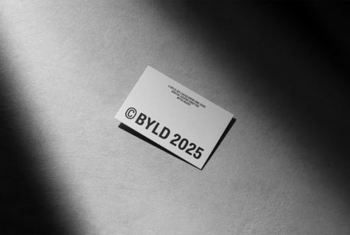 Black text on white business card mockup angled on gray textured surface