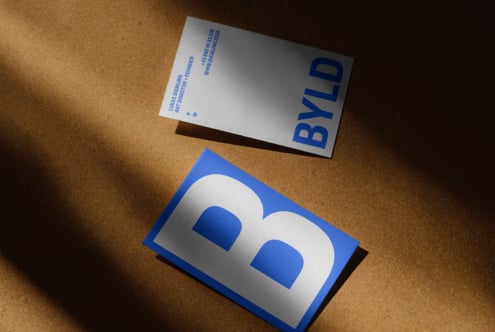 Business card mockup on corkboard featuring modern typography with blue and white design ideal for graphic designers and branding professionals templates