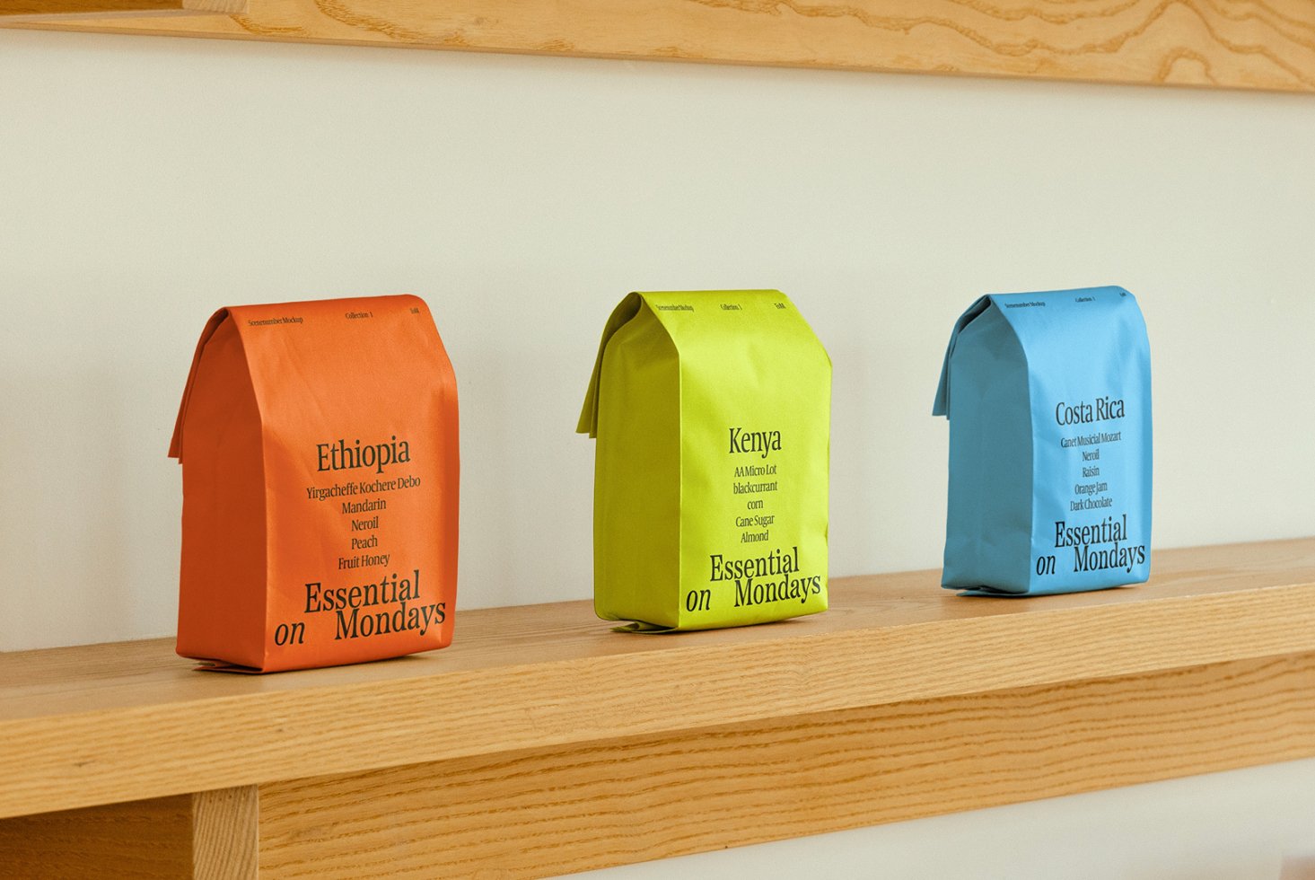 Three colorful coffee bag mockups on a wooden shelf displaying stylish typography from Ethiopia Kenya Costa Rica ideal for graphic design templates.